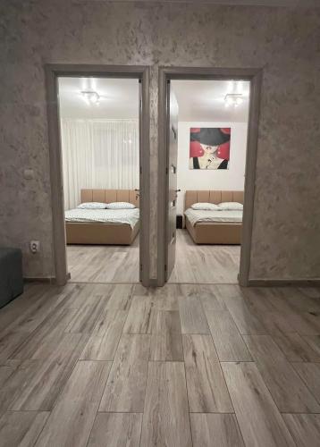 a large room with two beds and two mirrors at MODERN & ELEGANT Apartament in Craiova