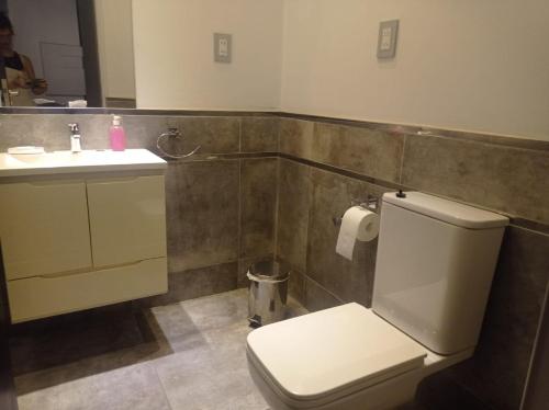 a bathroom with a white toilet and a sink at Altos Caution Apart in Concepción