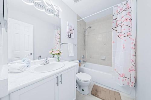 ein weißes Badezimmer mit einem Waschbecken, einem WC und einer Dusche in der Unterkunft Stylish & Cozy - 4Bdrm House Fast WIFI, 2.5 Bath in Barrie