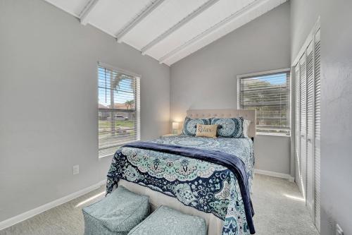 a bedroom with a bed and two windows at Sunny Sanctuary in Marco Island