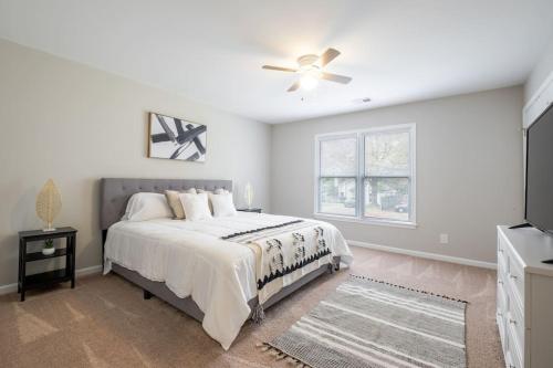 um quarto branco com uma cama e uma ventoinha de tecto em Stunning SouthPark/Cotswold Home em Charlotte