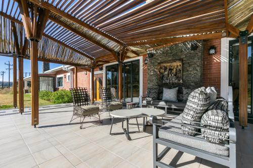 eine Terrasse mit einer hölzernen Pergola sowie Tischen und Stühlen in der Unterkunft Bali and Eva Midlands in Nottingham Road