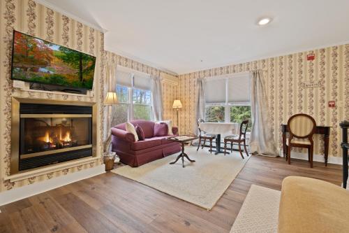 a living room with a couch and a fireplace at Brook Farm Inn in Lenox