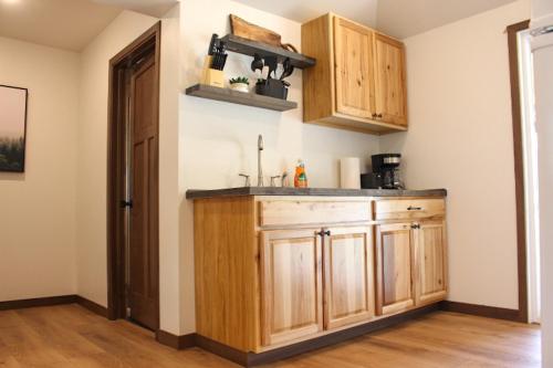 a kitchen with wooden cabinets in a room at Cabin 12 at Horse Creek Resort in Rapid City