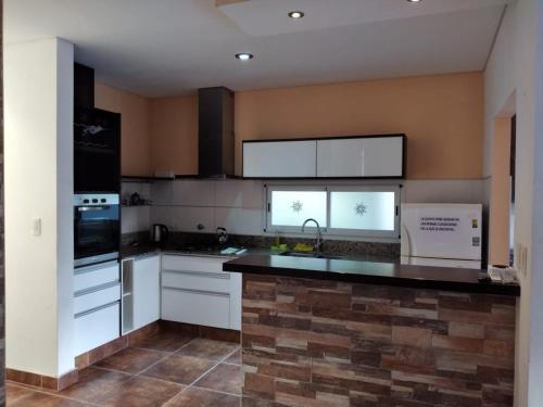 a kitchen with white cabinets and a black counter top at Casa Quinta Barrio Real in Junín