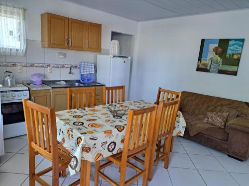 een keuken met een tafel en stoelen en een bank bij Tia Denise Pousada in Penha