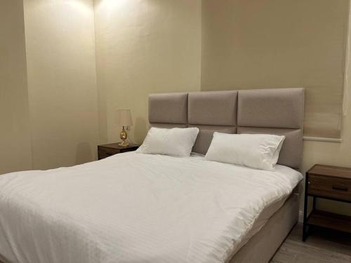 een slaapkamer met een groot wit bed met 2 kussens bij شقة دخول ذاتي بجلسة خارجيةModern Apartment North Ring 319 in Riyad