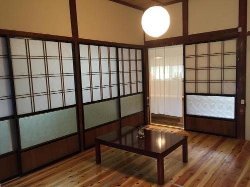 um quarto com uma mesa e algumas janelas em Satoyama Guest House Couture - Vacation STAY 43859v em Ayabe