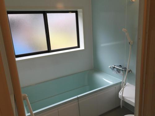 uma banheira na casa de banho com uma janela em Satoyama Guest House Couture - Vacation STAY 43859v em Ayabe