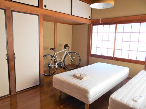 a bedroom with a bed and a bike on the wall at ゲストハウスみちしお 