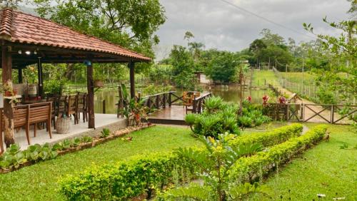 a garden with a gazebo and a table at Seu Refúgio Rural Piscina Privativa e Natureza in Tubarão
