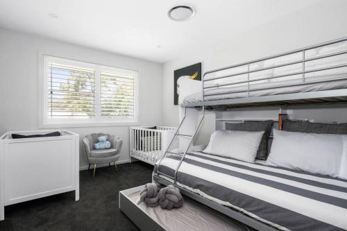 a bedroom with a bunk bed and a crib at Luxury at MacMasters Beach in Macmasters Beach