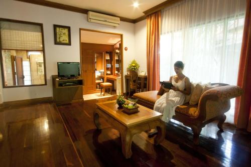 
a man sitting on a couch in a living room at Sunrise Tropical Resort in Railay Beach
