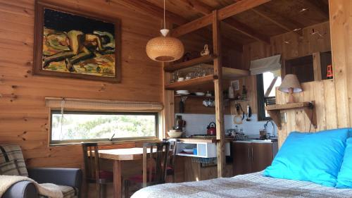 Una habitación con cama y una cocina en una cabaña en Horizonte Infinito, en Casablanca