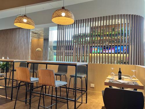 a bar with chairs and wine bottles in a restaurant at Holiday Inn Bogota Airport by IHG in Bogotá