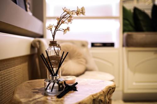 a table with a vase with flowers on it at Apartments Marconio Wellness Club in Belgrade