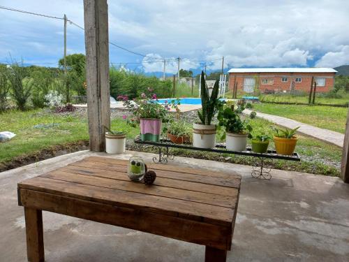 una mesa de madera en un patio con macetas en Puesta del Sol en Salta