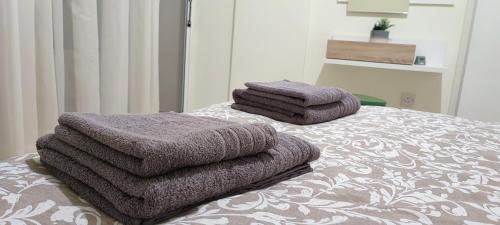 una pila de toallas sentadas encima de una cama en Pentadaktylos Mountain view apt 2 bedroom en Nicosia