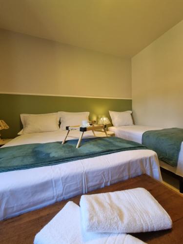 a room with two beds with a table on it at Frieden Haus Pousada in Pomerode
