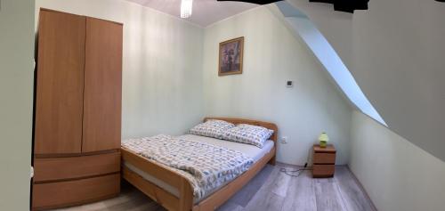 a small bedroom with a bed and a staircase at Nad Strumykiem 1 in Duszniki Zdrój