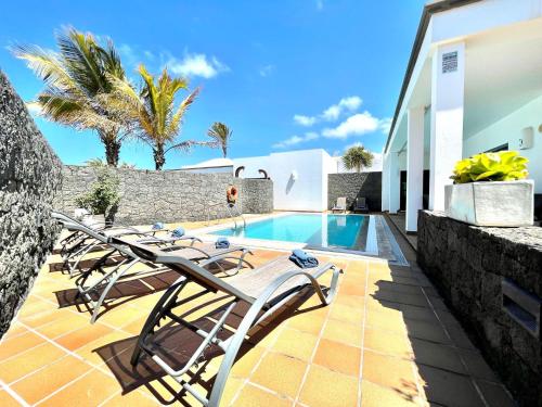 Villa con piscina y algunas sillas en Villas Mamma Mia pool heat Private & Jacuzzi, en Playa Blanca
