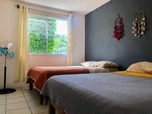 um quarto com duas camas e uma janela em Tu refugio en Tequesquitengo Casa once88 em Tlatenchu