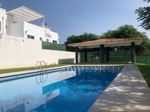 a swimming pool with a gazebo next to a house at "Escapada perfecta" casa con albeca, jacuzzi y roof garden in Tlatenchu