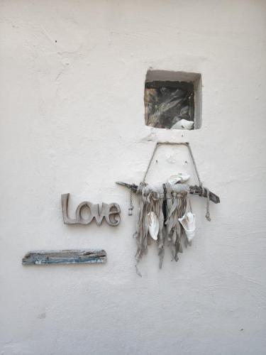 a wall with a love sign and a window at The Suite. Few steps & beach! in Chelem