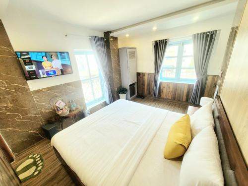 Thung Lũng Kim Khuê Villas في دالات: غرفة نوم بسرير كبير وتلفزيون بشاشة مسطحة