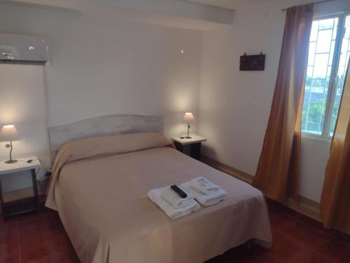 1 dormitorio con 1 cama con 2 toallas en Flor de Cardón en La Rioja