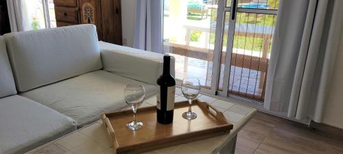 una botella de vino y dos copas de vino en una mesa en Cabaña El Huerto en San Rafael