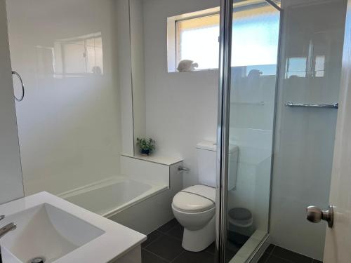 ein weißes Bad mit einem WC und einer Dusche in der Unterkunft Camelot 14, 68-70 Little Street, Forster in Forster
