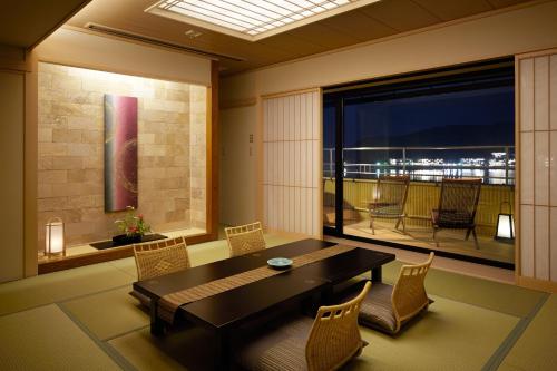 a dining room with a table and chairs and a balcony at Fujikawaguchiko Onsen Konanso in Fujikawaguchiko