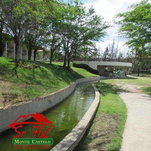 a canal in a park with trees and a building at Sr.Flat Monte Castelo in Bezerros
