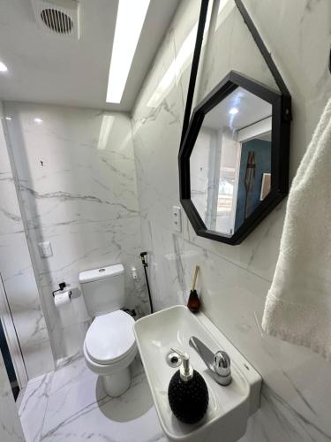 a white bathroom with a toilet and a sink at Nannai Residence Porto Galinhas Praia Muro Alto 101 in Porto De Galinhas