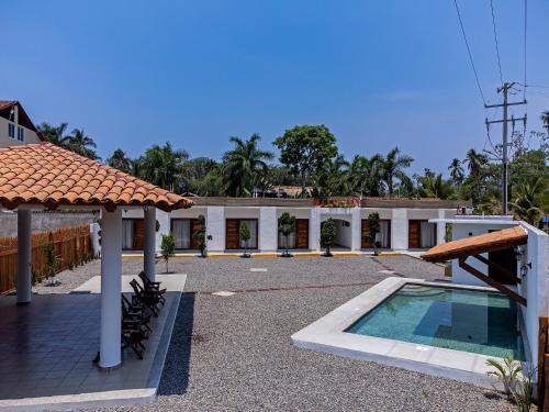 un edificio con piscina frente a él en HOTEL CASA VICTORIA en Zihuatanejo