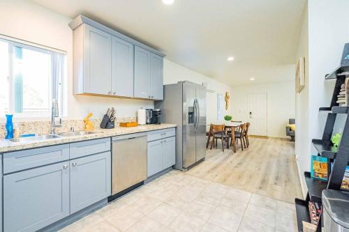 a kitchen with stainless steel appliances and a table at Stylish 2B2B country style house in Glendora