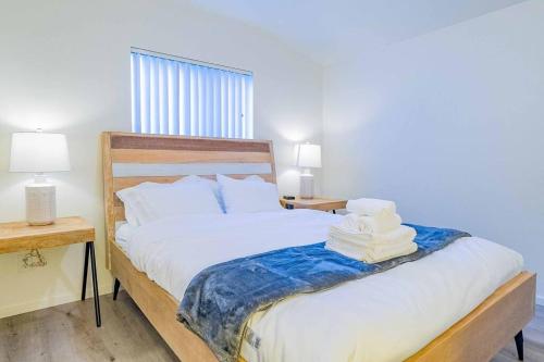 a bedroom with a bed with white sheets and two lamps at Stylish 2B2B country style house in Glendora