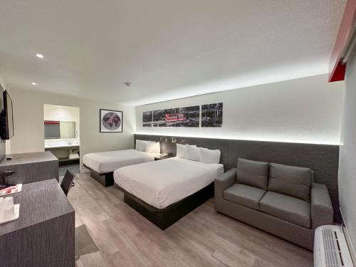 a hotel room with a bed and a couch at Ramada by Wyndham Anaheim Convention Center in Anaheim