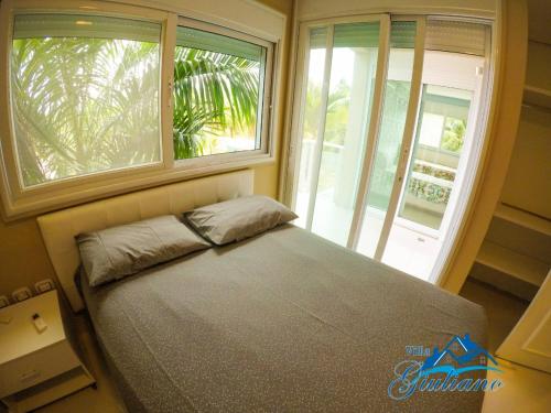 a bedroom with a bed in front of a window at Villa Giuliano no Hibiscus Beach Clube Ipioca Maceio in Maceió