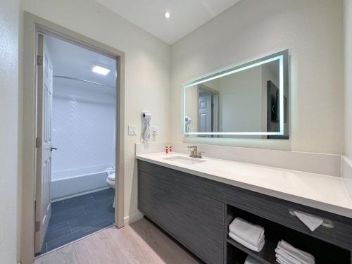a bathroom with a sink and a mirror at Ramada by Wyndham Anaheim Convention Center in Anaheim