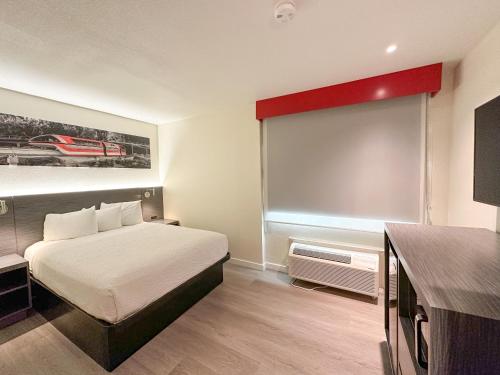 a hotel room with a bed and a window at Ramada by Wyndham Anaheim Convention Center in Anaheim