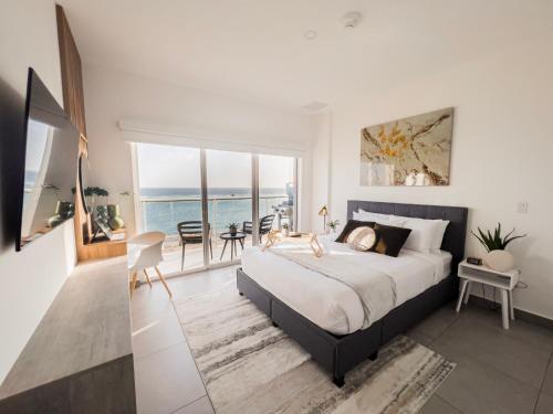 Un dormitorio con una cama y vista al mar. en Upscaled And Modern Oceanfront Apartment, en Oranjestad