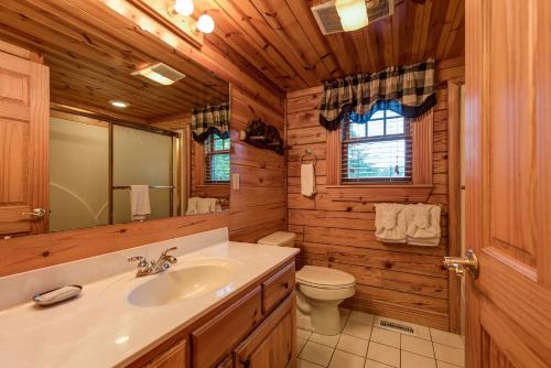 a bathroom with a sink and a toilet in a log cabin at Return To Me, 3 Bedrooms, Sleeps 9, Pool Table, Hot Tub, Gas Fireplace in Sevierville