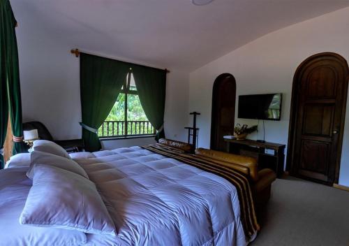 a large bed in a bedroom with a large window at Fundo El Chocho in Cajamarca