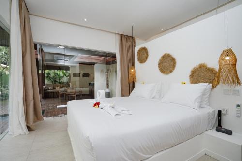 una camera con un grande letto bianco e un soggiorno di Villa Pulau I, 1BR Luxury Private Villa with Pool in North of Bali, Pemuteran, within Walking Distance to a Wild Beach a Buleleng