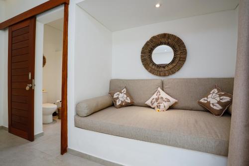 un soggiorno con divano e specchio di Villa Pulau I, 1BR Luxury Private Villa with Pool in North of Bali, Pemuteran, within Walking Distance to a Wild Beach a Buleleng
