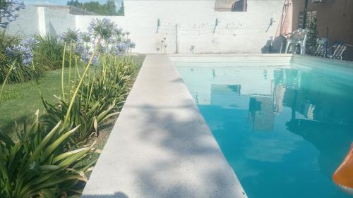 una piscina con una pasarela junto a una casa en Casa Olivia en Villa María
