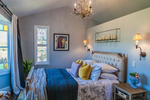 sypialnia z łóżkiem z niebieską pościelą i żółtymi poduszkami w obiekcie Wollombi Wines w mieście Wollombi