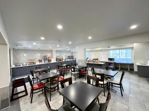 a restaurant with tables and chairs and a kitchen at Ramada by Wyndham Anaheim Convention Center in Anaheim